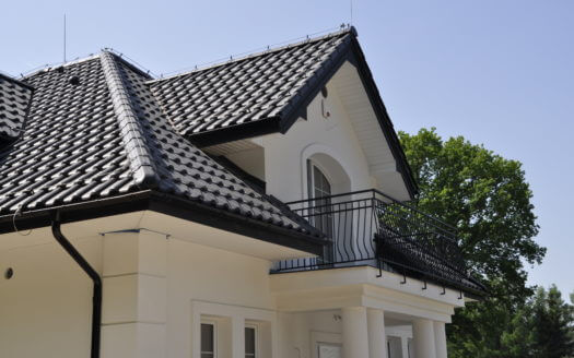 piętrowy dom z czarnym dachem i białymi ścianami po budowie przez firmę budowlaną MM Bujek