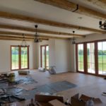przestrzenny salon z drewnianymi panelami i oknami tarasowymi po remoncie przez firmę budowlaną MM Bujak